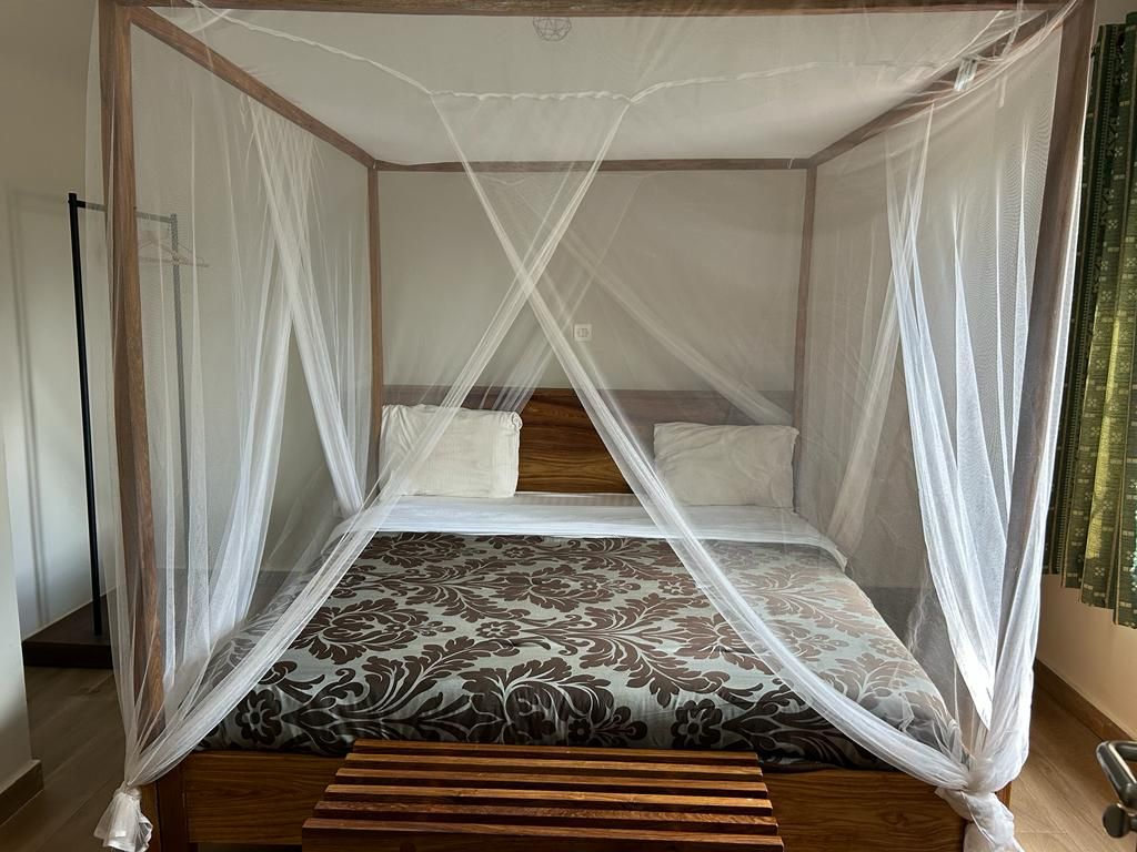 Nouvelle chambre à l'Hotel Masabi (Kindia, Guinée), offrant confort et élégance avec un lit double, une salle de bain privative équipée d'eau chaude, une climatisation et une moustiquaire.