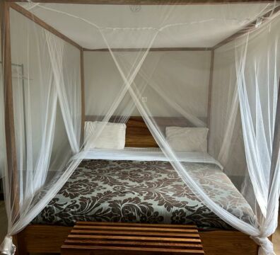 Nouvelle chambre à l'Hotel Masabi (Kindia, Guinée), offrant confort et élégance avec un lit double, une salle de bain privative équipée d'eau chaude, une climatisation et une moustiquaire.