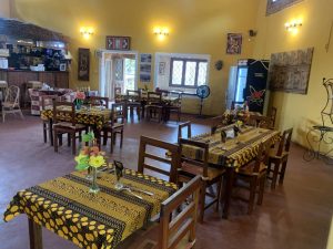 Vue d'en haut du restaurant de l'Hotel Masabi à Kindia, Guinée, avec de nombreuses tables et un bar à cocktails, offrant une atmosphère animée